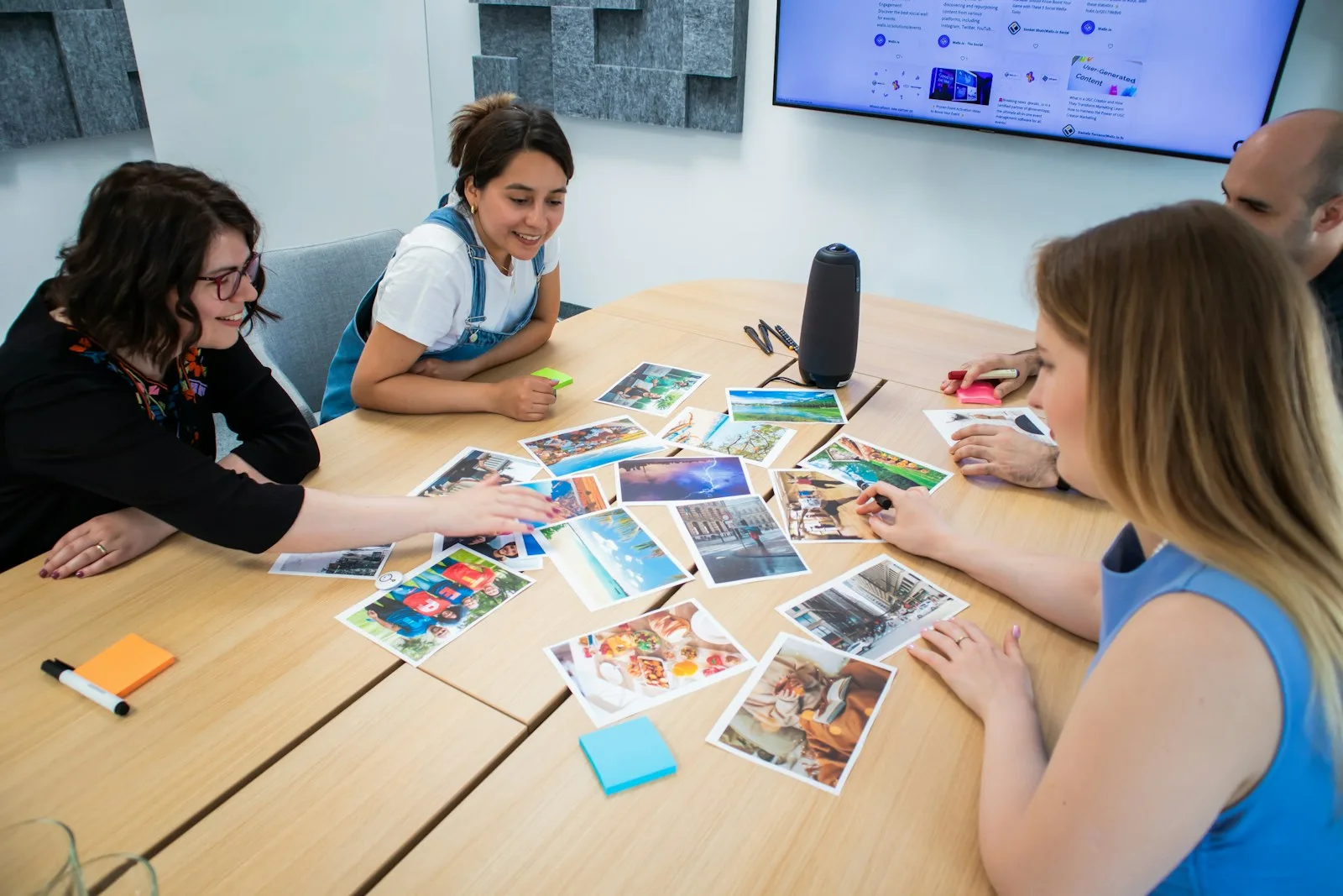 Creative marketing team reviewing campaign imagery together around a table.